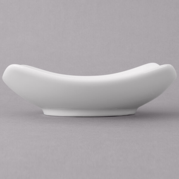 A Schonwald white porcelain square bowl with curved edges.