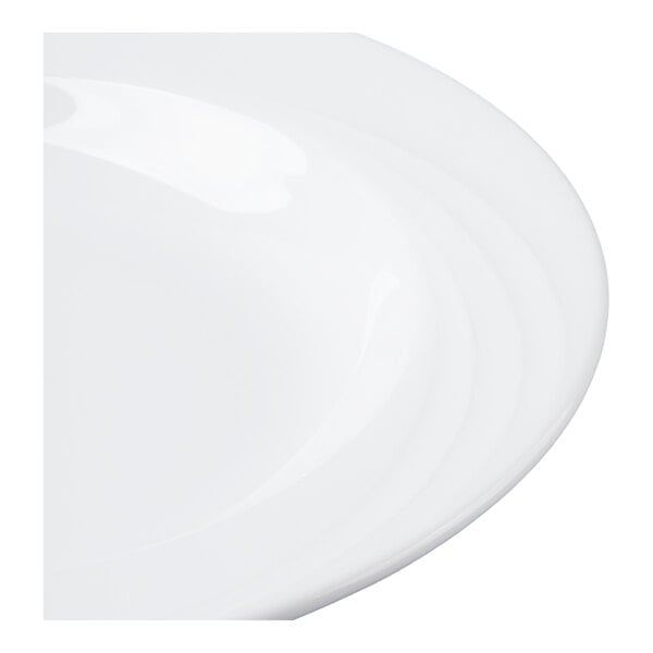 A close-up view of a glossy white bowl with a wide rim and subtle concentric circular patterns.