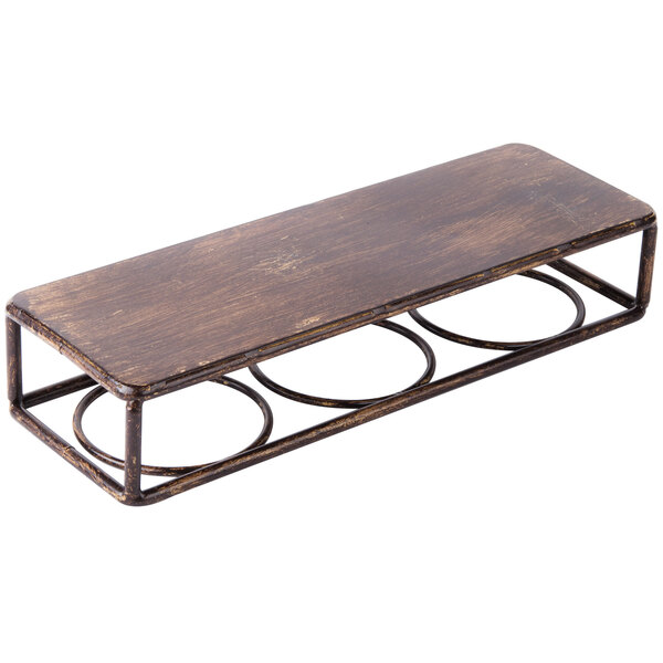 A brown metal Clipper Mill by GET rectangular shelf with three metal rings on a brown wooden table.