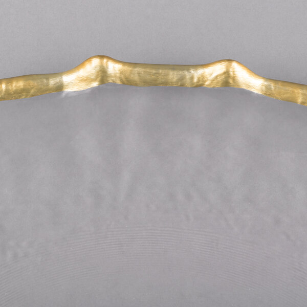 A Charge It by Jay clear glass charger plate with a gold rim.