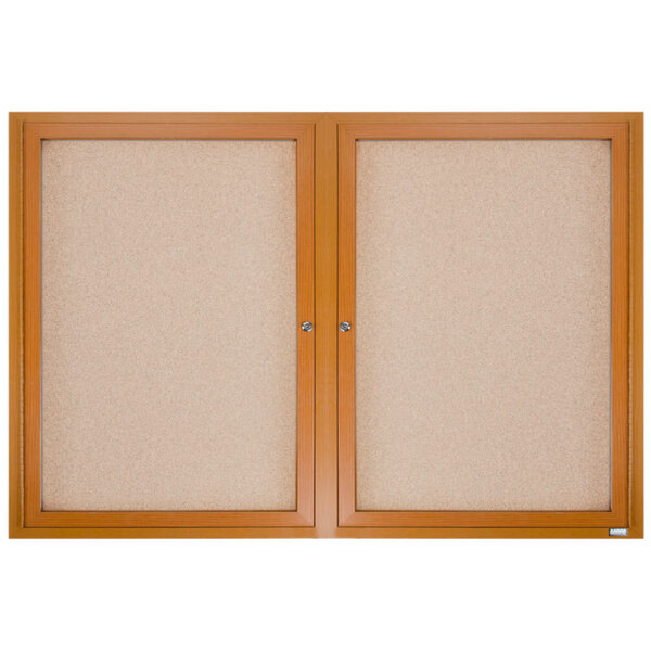 Two Aarco enclosed bulletin boards with natural oak frames and two doors.