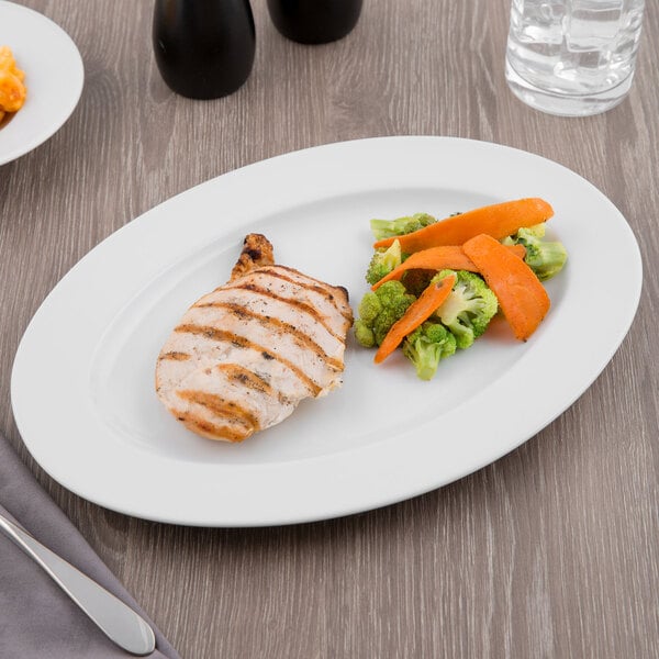 A Schonwald white porcelain platter with chicken, carrots, and broccoli on it.