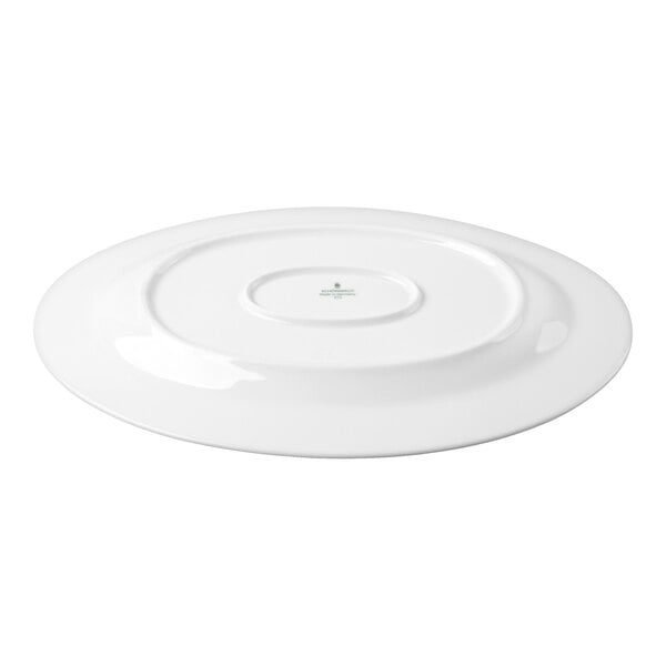 A white oval porcelain platter shown upside down, displaying its smooth underside and a small central logo or marking.