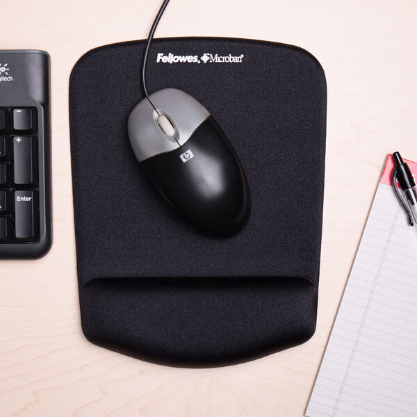 A black mouse pad with a wrist rest and a mouse on it.