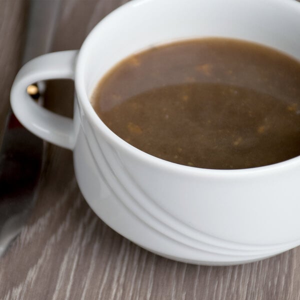A white Schonwald two-handled soup cup on a table.