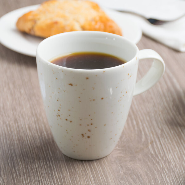 A Schonwald white porcelain cup filled with coffee on a table.