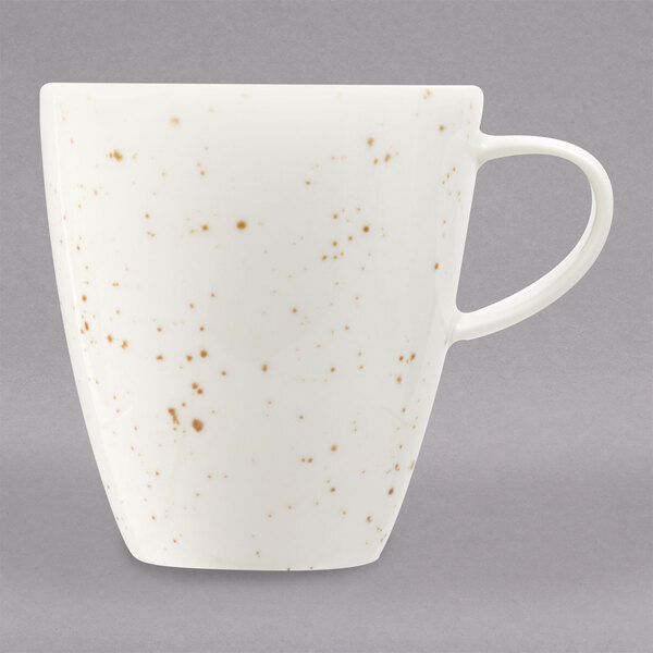 A white porcelain cup with brown specks.