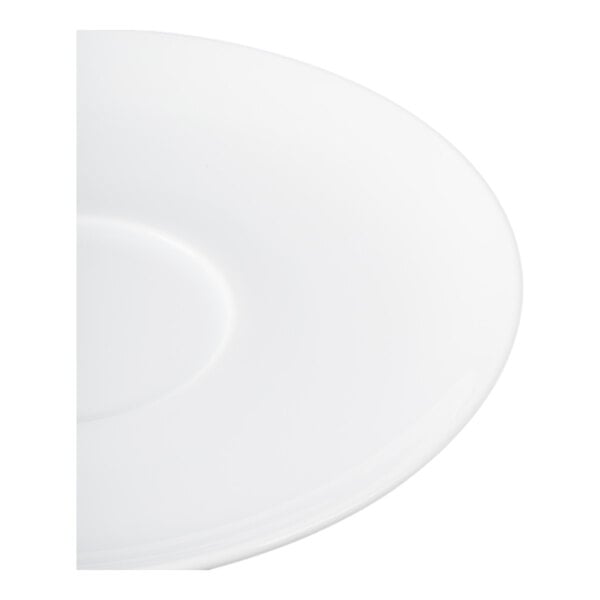 A partial view of a plain white round saucer with a slight indentation in the center.