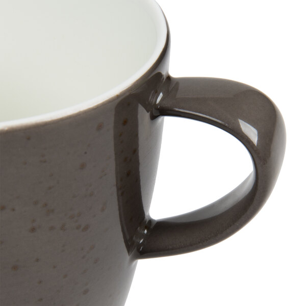 A close-up of a Schonwald dark gray porcelain coffee cup with a handle.