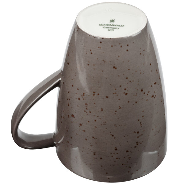 A dark gray porcelain mug with a brown speckled design and a handle.