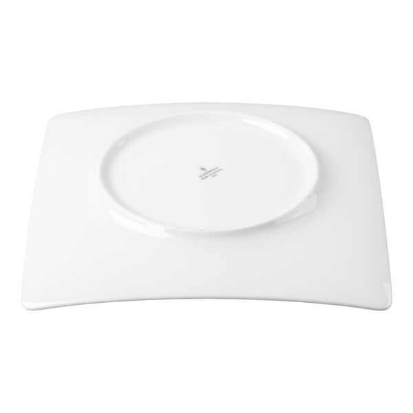 A white, square porcelain plate shown upside down on a white background.