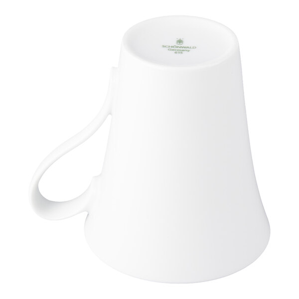 A white porcelain cup is shown upside down with a curved handle visible.