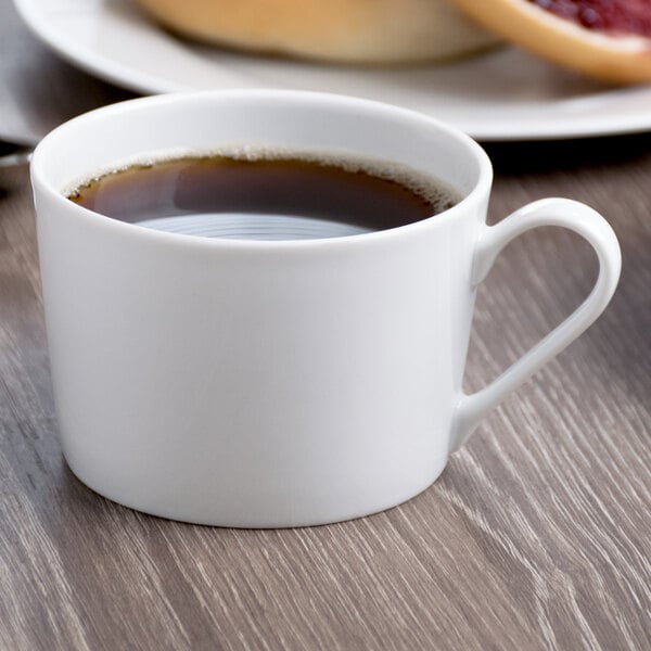 A Schonwald white porcelain cup of coffee on a table.