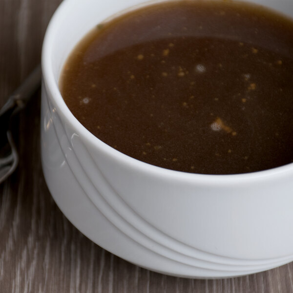 A white Schonwald porcelain bowl filled with brown liquid.