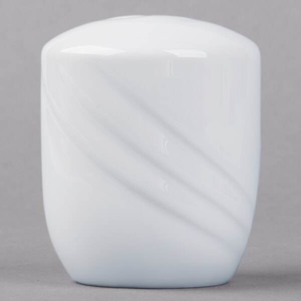A white porcelain salt shaker with a curved design.