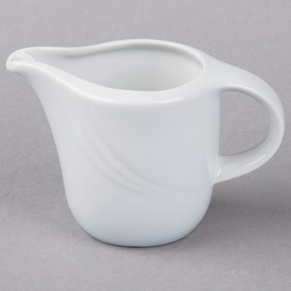 A Schonwald white porcelain creamer with a handle.