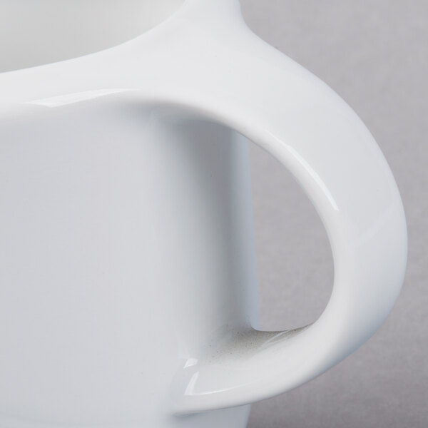 A Schonwald white porcelain creamer with a handle.