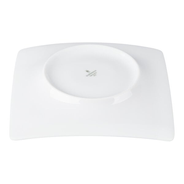 A white, square porcelain saucer with a circular indentation in the center, viewed from above.