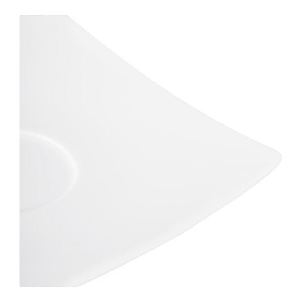 A close-up view of a white, square-shaped porcelain saucer with a slightly raised edge and a circular indentation.