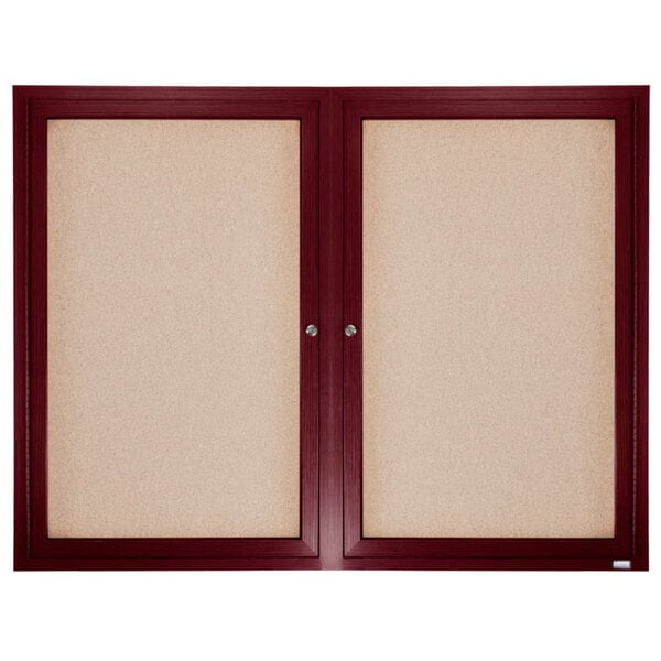 Aarco enclosed bulletin board with cherry wood frame and cork board behind two doors.