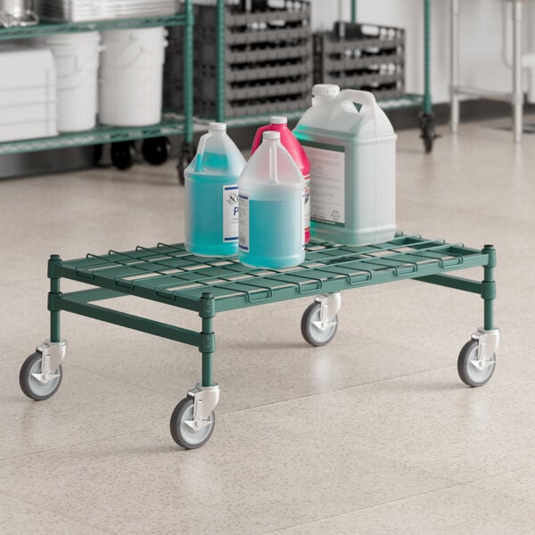 A green metal cart with bottles of liquid on it with a white mat on the bottom.