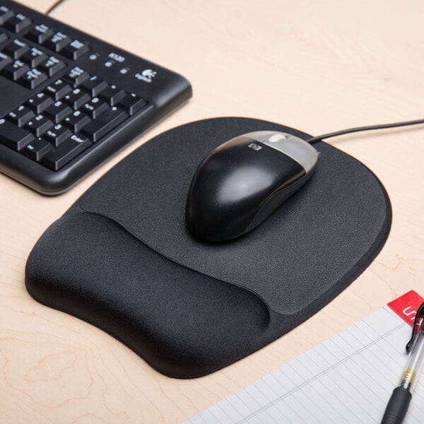 A Fellowes black mouse pad with a foam wrist rest with a mouse on it next to a keyboard.