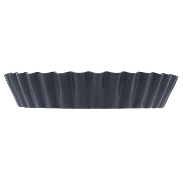 A black steel Matfer Bourgeat fluted tartlet/quiche mold.