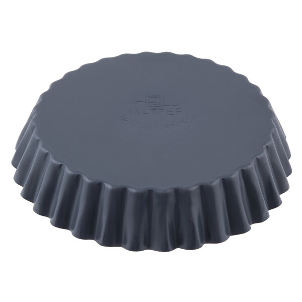 A black round Matfer Bourgeat fluted quiche mold.