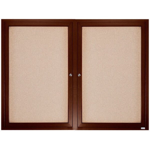 A brown wooden framed Aarco enclosed bulletin board.