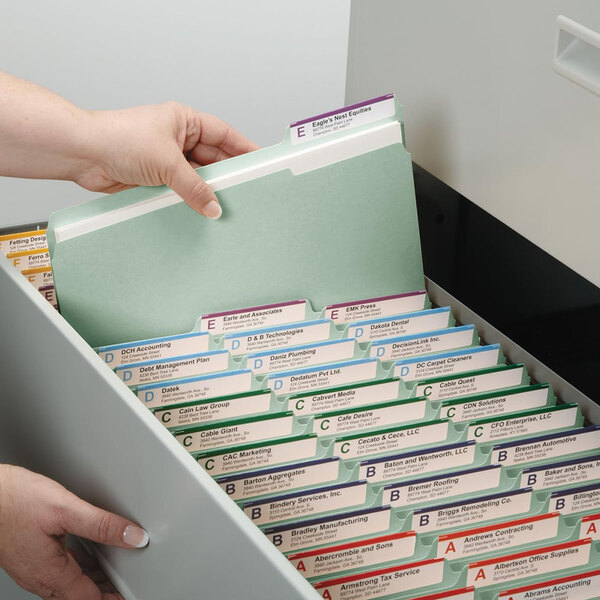 A hand picking up a Smead file folder from a file drawer.