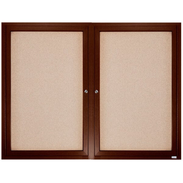 A white rectangular Aarco bulletin board with a brown wooden frame.