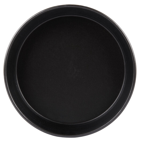 A black round pan with a black surface.