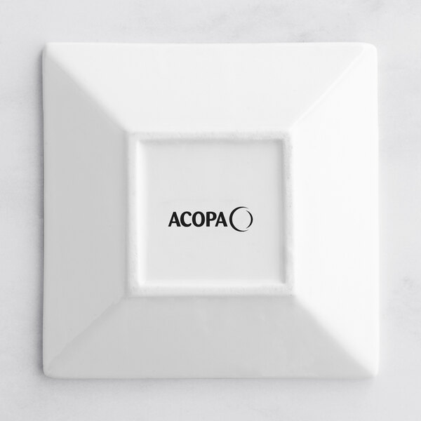 A white square Acopa porcelain saucer with black text.