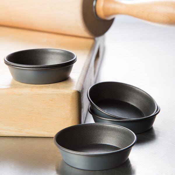 Three Matfer Bourgeat non-stick round mini cake pans on a table.