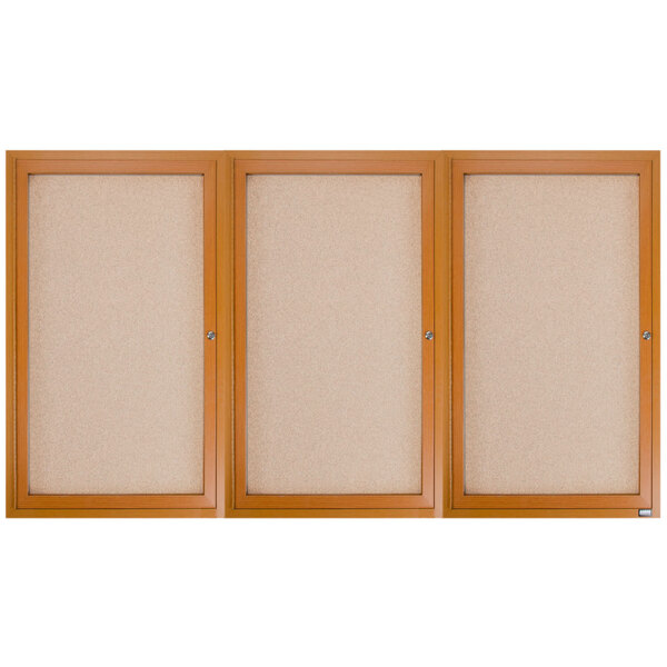 Three Aarco wooden framed bulletin boards with three doors over cork boards.