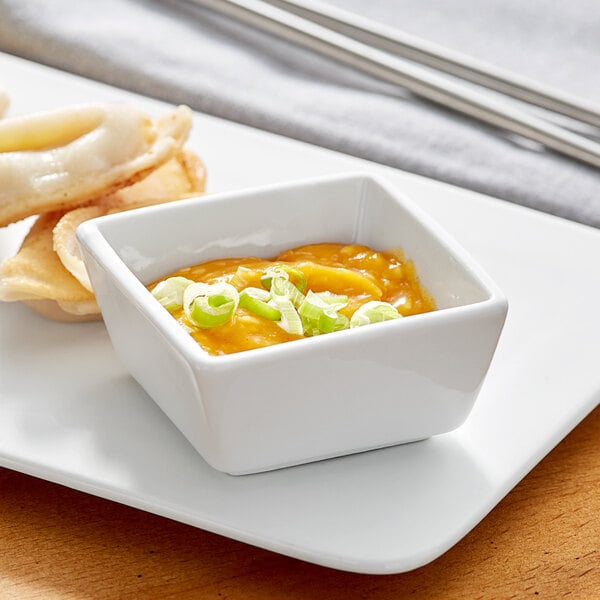 An Acopa bright white square porcelain bowl with food on it.