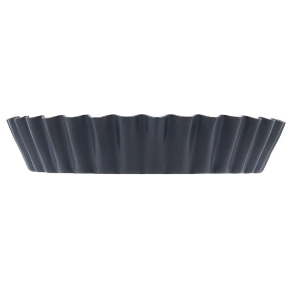 A black steel tart/quiche pan with fluted edges.