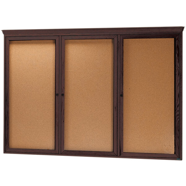 A walnut wooden enclosed bulletin board with three cork doors.