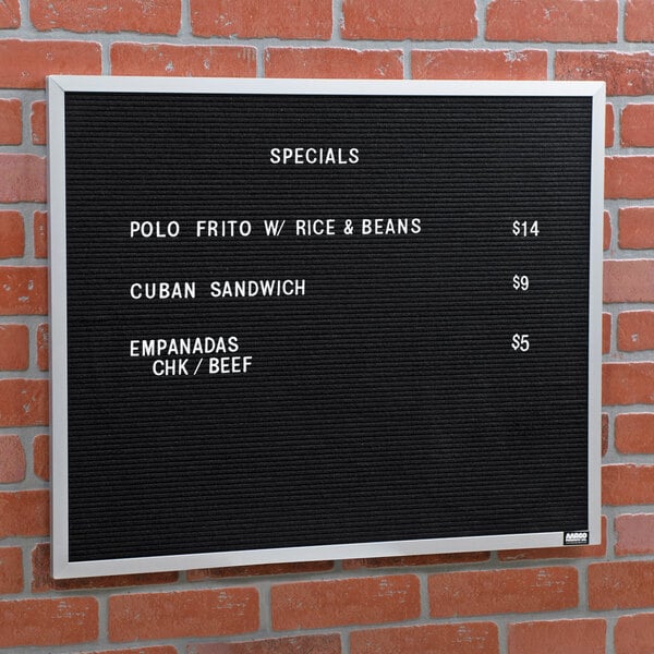 A black Aarco open face message board with white text on it.