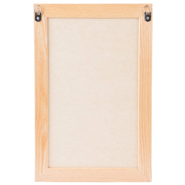An Aarco black felt message board with an oak wood frame.
