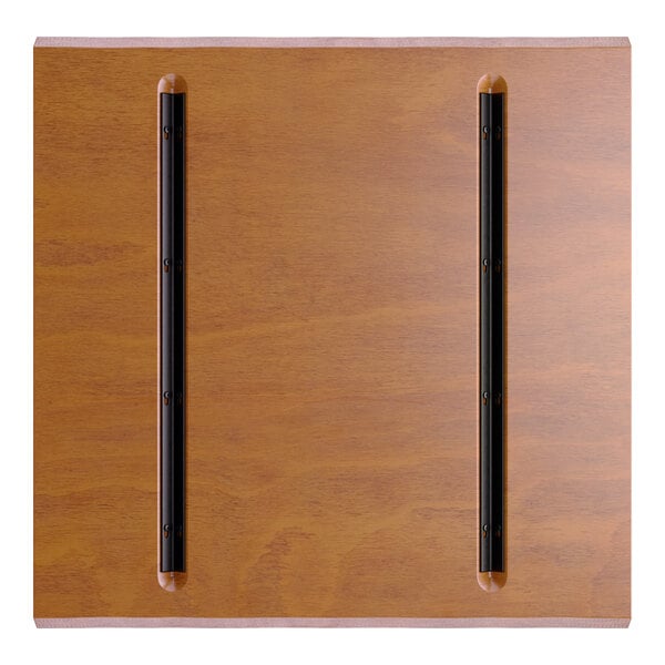 A square wooden surface with a warm brown finish and two parallel black metal strips attached vertically.