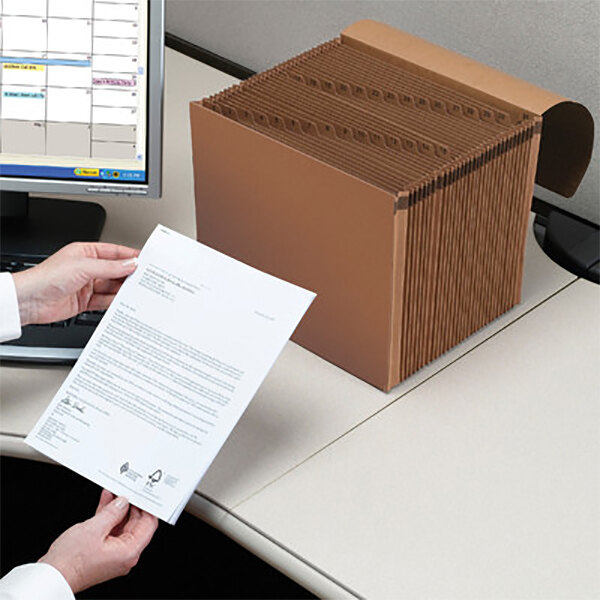 A person holding a piece of paper next to a redrope file folder.