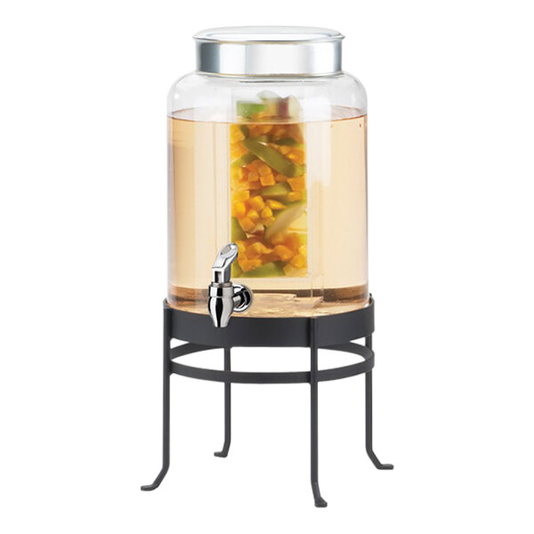 A Cal-Mil black glass beverage dispenser with liquid in it on a table.