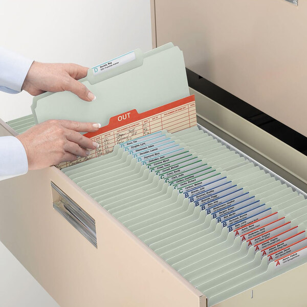 A person using Smead file folders to organize a file cabinet.