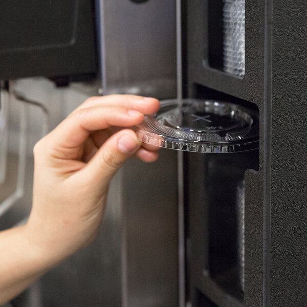 A close-up of a black Vollrath countertop lid organizer with a straw pocket.