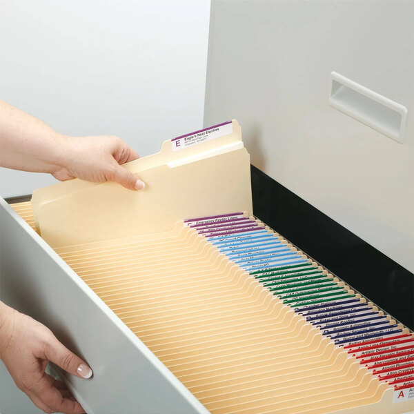 A person opening a file drawer with Smead manila file folders.