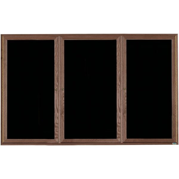 A black felt message board with wooden doors.