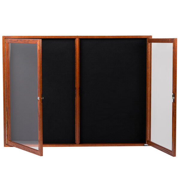 A black board with a wooden frame and glass doors.