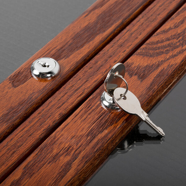 A close-up of two keys on a wooden table.