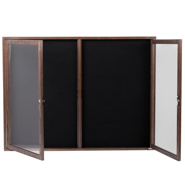 A black felt message board with a wooden frame and glass doors.